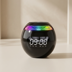A spherical black digital alarm clock with a glossy finish, a digital LED display showing 09:00, and a colorful rainbow light band around its upper half, set on a light beige surface against a matching background.