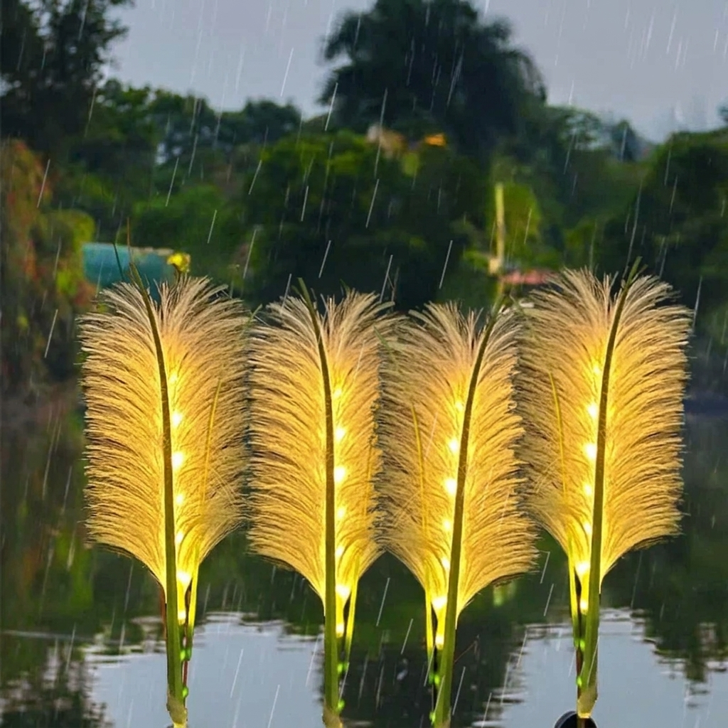 Four glowing decorative reed-like lights standing upright in shallow water during rain, with blurred trees in the background.