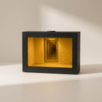 A rectangular black shadow box lamp featuring a glowing yellow miniature hallway interior, set against a warm beige background with soft shadows.