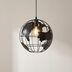 A black metal globe pendant light with a wire cage design and silhouette map of continents, featuring a glowing warm Edison bulb inside, suspended against a plain off-white wall.