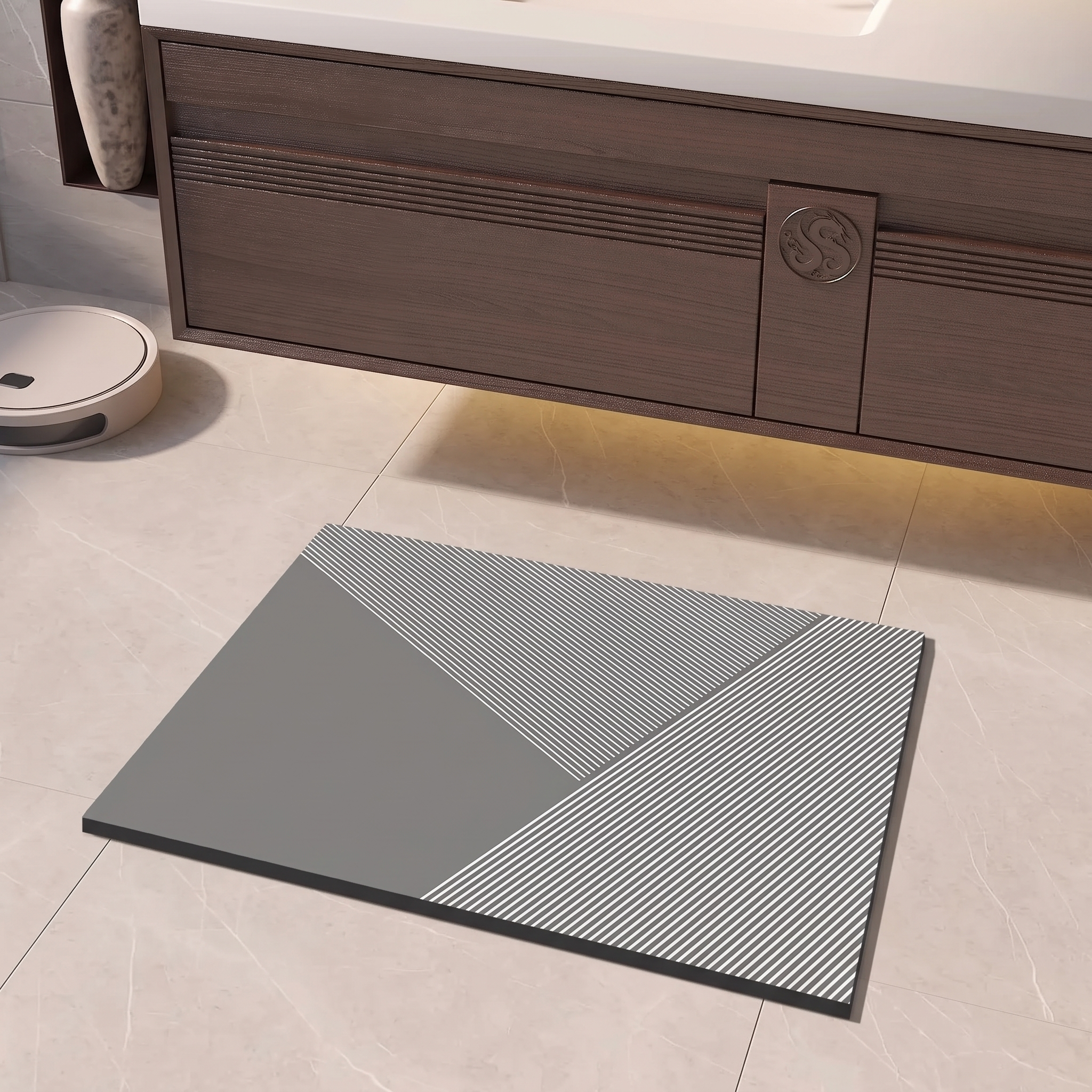 A rectangular gray bath mat with a geometric pattern of solid gray and black-and-white striped sections, placed on a light beige tiled bathroom floor in front of a dark wood vanity.