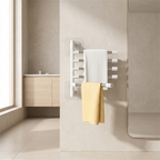 A modern wall-mounted heated towel rail in a clean bathroom setting, holding a white towel and a yellow towel. The product is mounted on a textured beige wall with a window and vanity visible in the background.