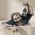 A zombie Halloween decoration with a raised arm holding a black lantern, posed on top of a beige pedestal against a neutral beige background.