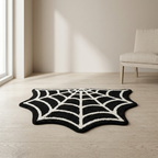 A black and white spiderweb-patterned rug styled on a light wood floor in a minimalist room with a beige wall and a light-colored chair.