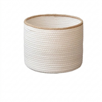 A cylindrical rope storage basket in off-white with a natural tan jute trim along the rim, shown on a plain white background.