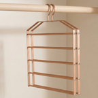 A rose gold metal closet organizer hanger with five horizontal bars, suspended from a wooden closet rod against a neutral beige background.