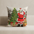 A square decorative throw pillow featuring a festive Christmas illustration of Santa Claus decorating a tree, shown resting on a light beige upholstered surface against a neutral wall.