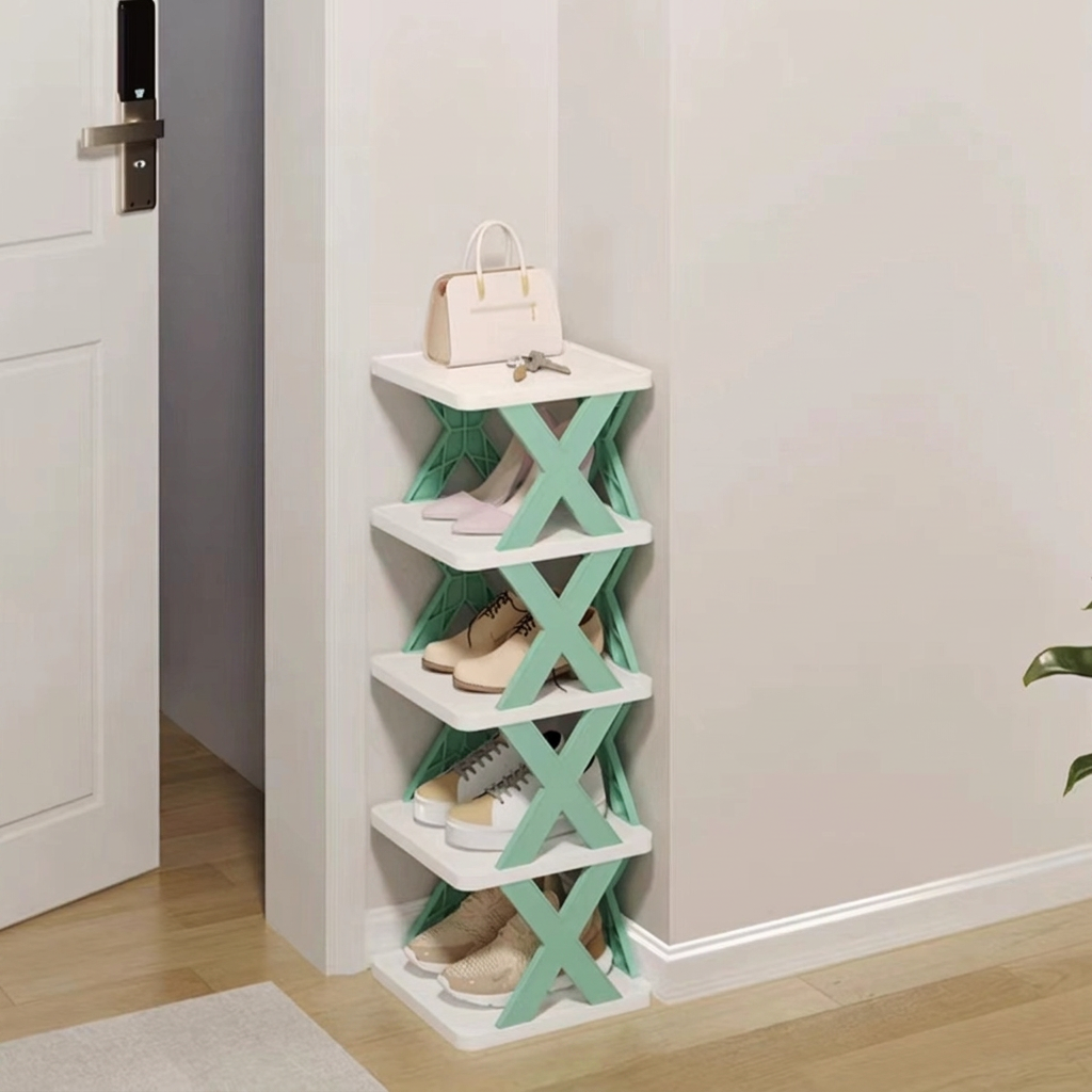A 4-tier shoe rack with white shelves and mint green X-shaped supports, shown in a home entryway corner with shoes and a handbag on it.