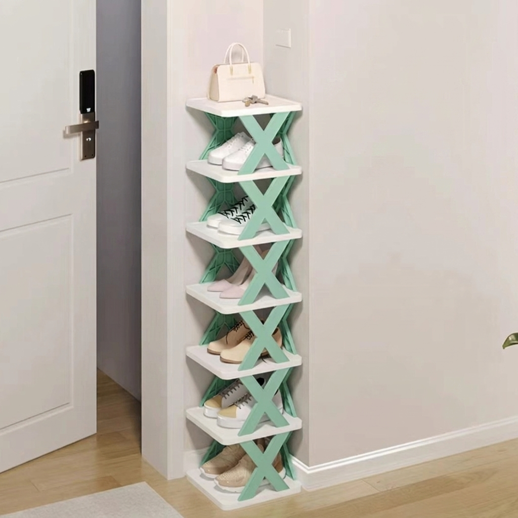 A 5-tier folding shoe rack with white shelves and mint green X-shaped side supports, shown in a home entryway next to a white door with shoes stored on the shelves.