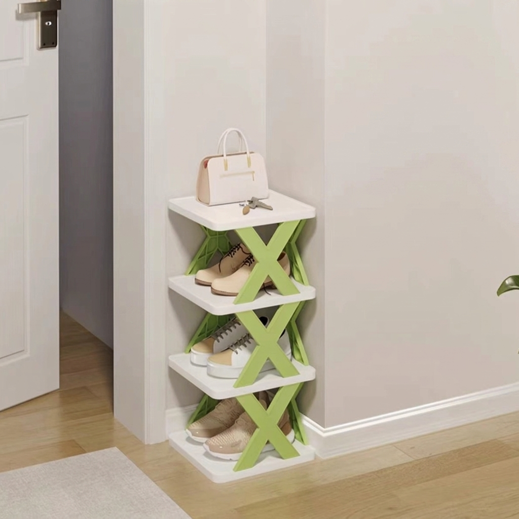 A 4-tier white and light green X-shaped shoe storage rack placed in a hallway corner, holding various shoes, with a handbag and keys on the top shelf.