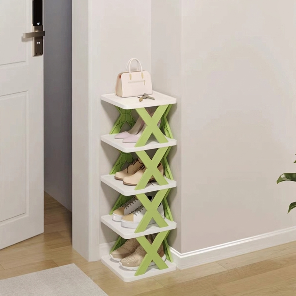 A 4-tier shoe rack with white shelves and lime green X-shaped side supports, shown in a home entryway corner next to a door with shoes and a handbag stored on it.