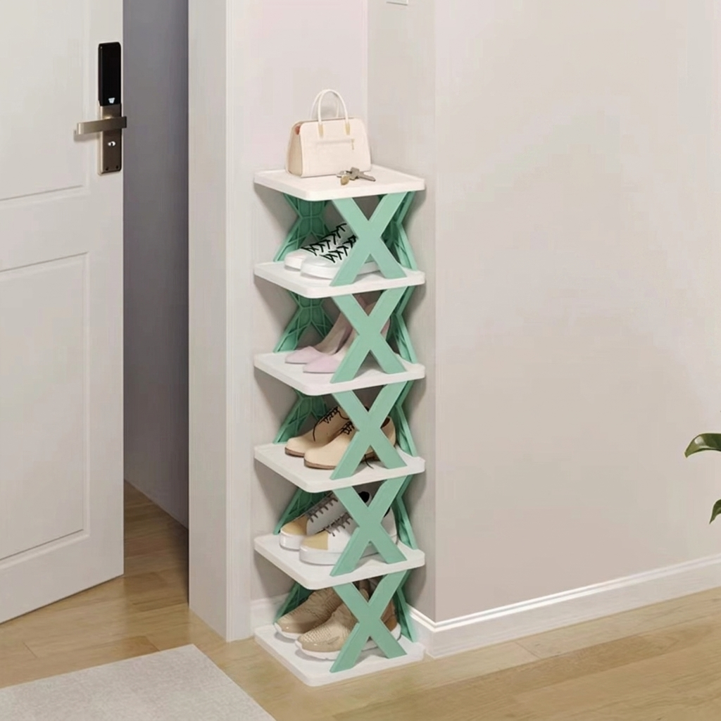 A 5-tier white shoe rack with mint green X-shaped side supports, shown in a home entryway next to a door, holding various shoes and a handbag.