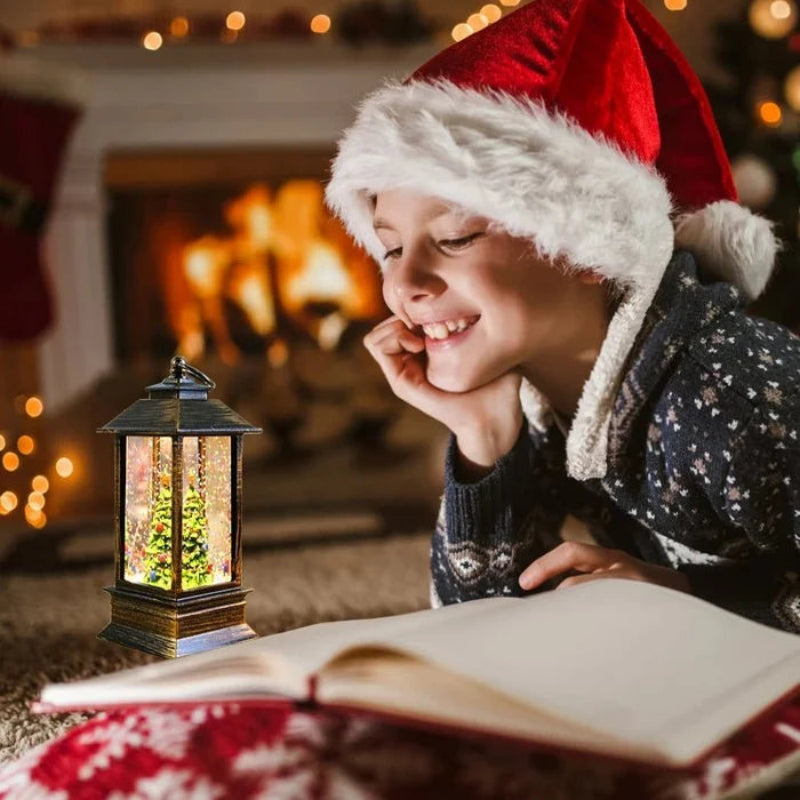 A child wearing a red Santa hat and dark patterned sweater lies on the floor by a warm fireplace, smiling at an open book with a glowing lantern nearby.