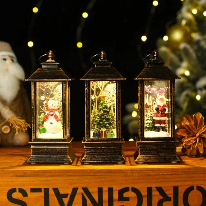 Three decorative lanterns with Christmas scenes inside, on a wooden surface with festive decorations.