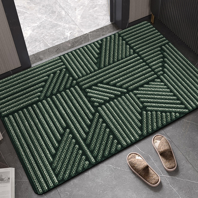 Green geometric patterned rug on a gray floor with slippers nearby.