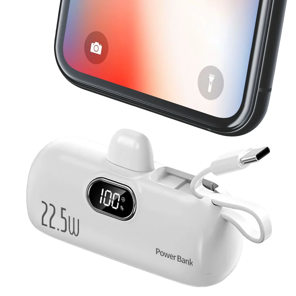 White power bank with digital display and charging cable, next to a smartphone showing camera and flashlight icons.