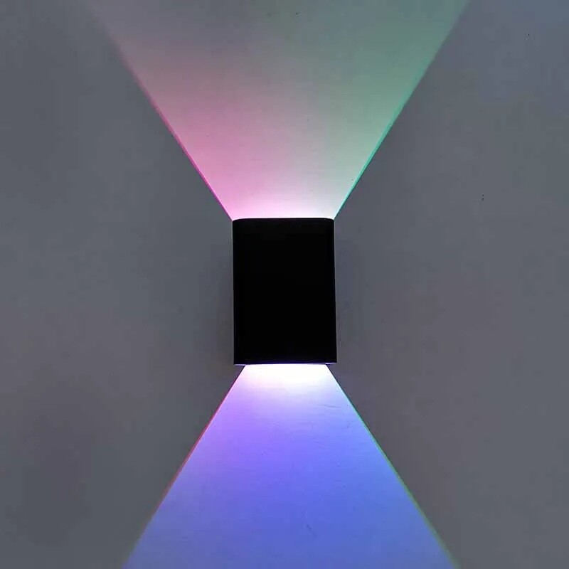 Black wall light fixture with RGB color-changing light on a gray wall.