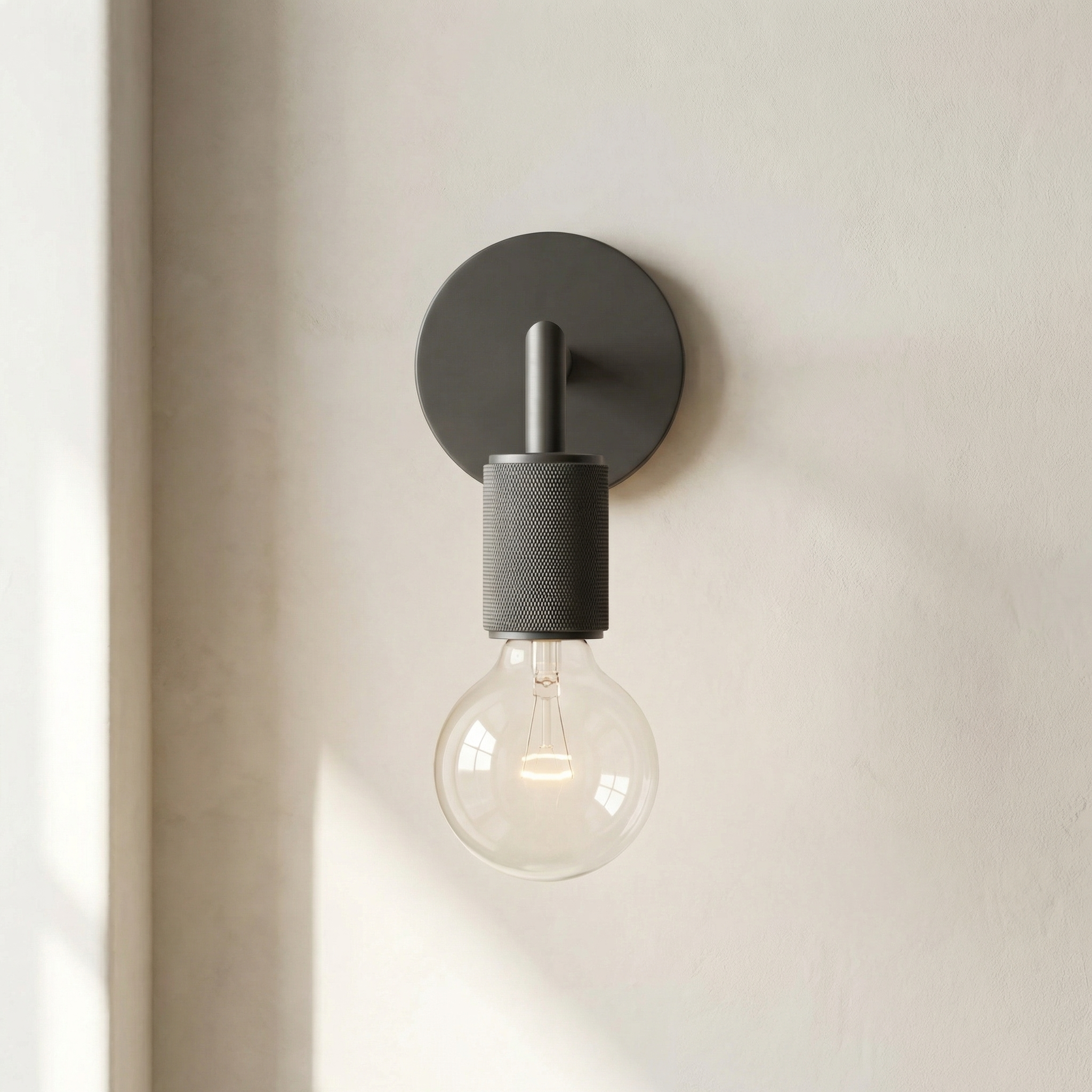 Modern wall-mounted light fixture with a single bulb on a neutral background