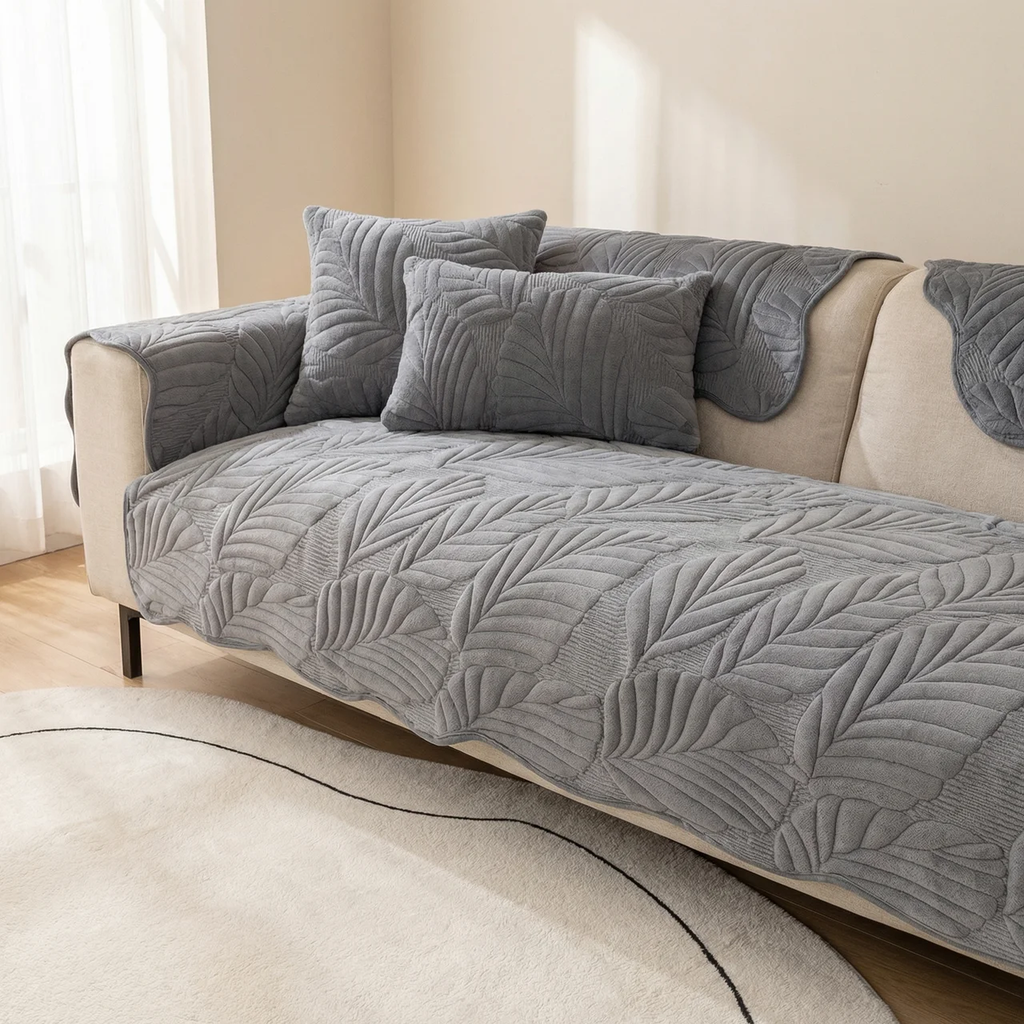 Gray textured sofa cover on a beige sofa with matching pillows in a living room setting.