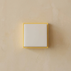 Square light switch with yellow frame on beige wall