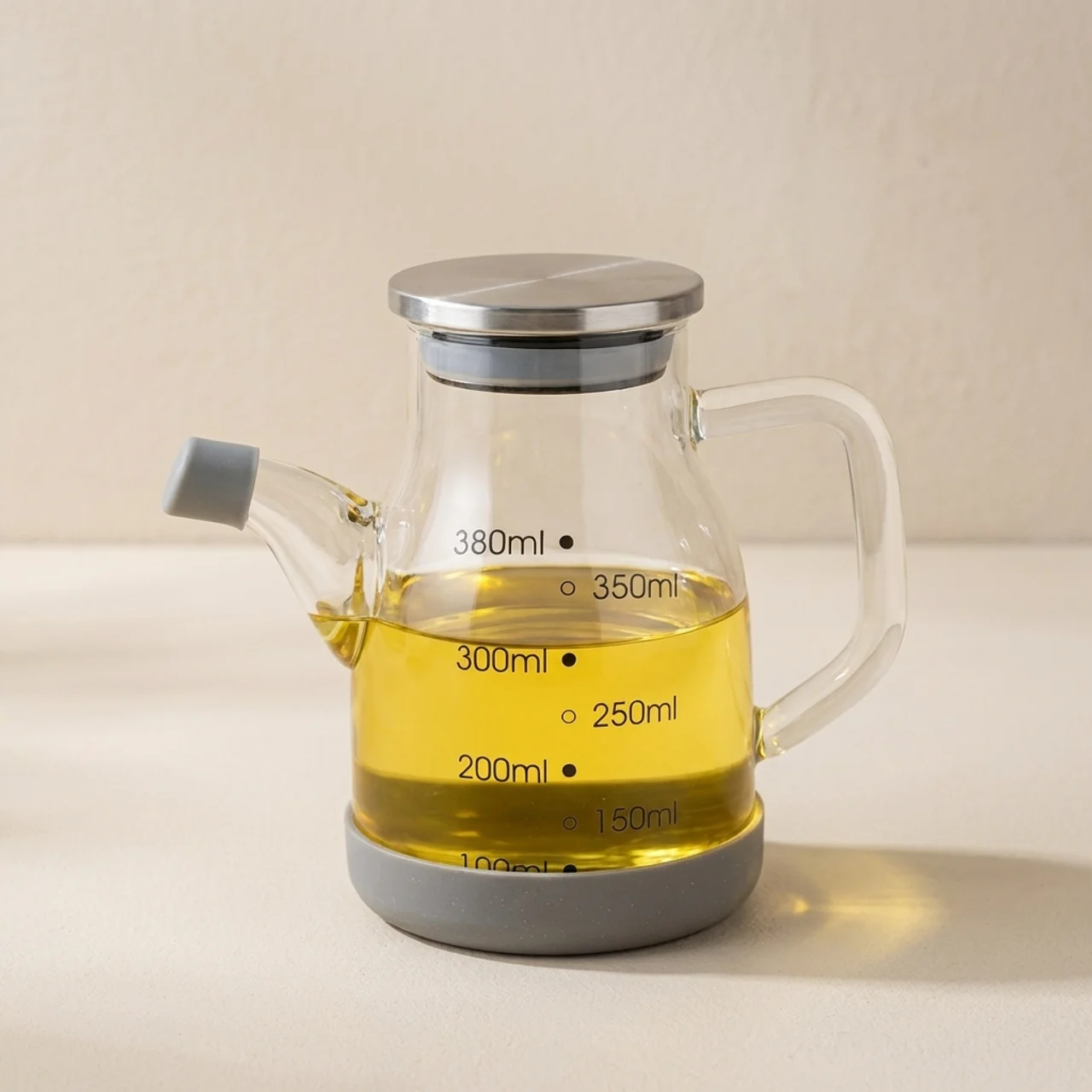 Glass measuring jug with oil and measurement markings on a neutral background