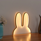 Bunny-shaped LED night light on a wooden surface with a neutral background