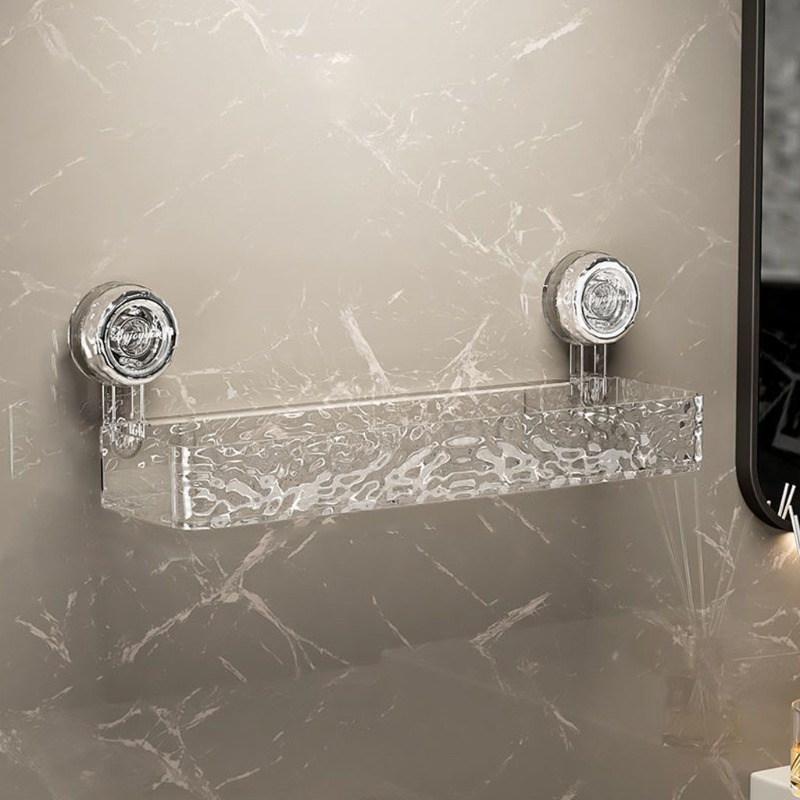 Clear glass shelf with silver brackets on a marble wall