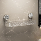 Clear glass shelf with silver brackets on a marble wall