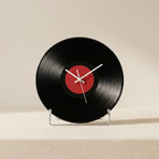 Vinyl record clock with a red center on a beige background