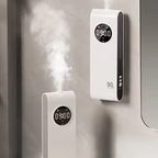 Two white humidifiers with digital displays on a neutral background