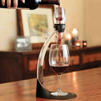 Wine being poured from a decanter into a glass on a wooden table.