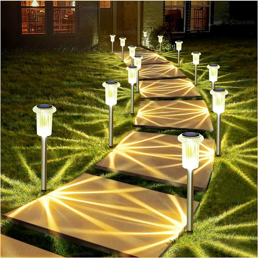 Solar pathway lights illuminating a set of outdoor steps on a grassy area.