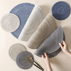 Set of round woven placemats in various colors on a neutral background