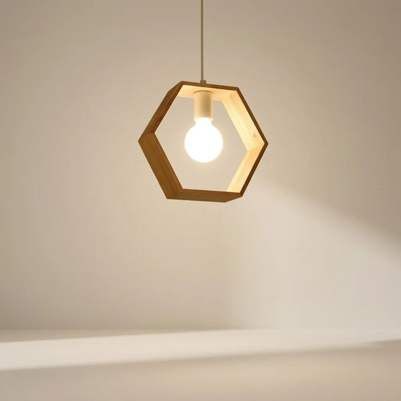 Hexagonal pendant light with a glowing bulb on a neutral background