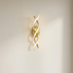 Gold wall sconce with wavy design on a neutral background