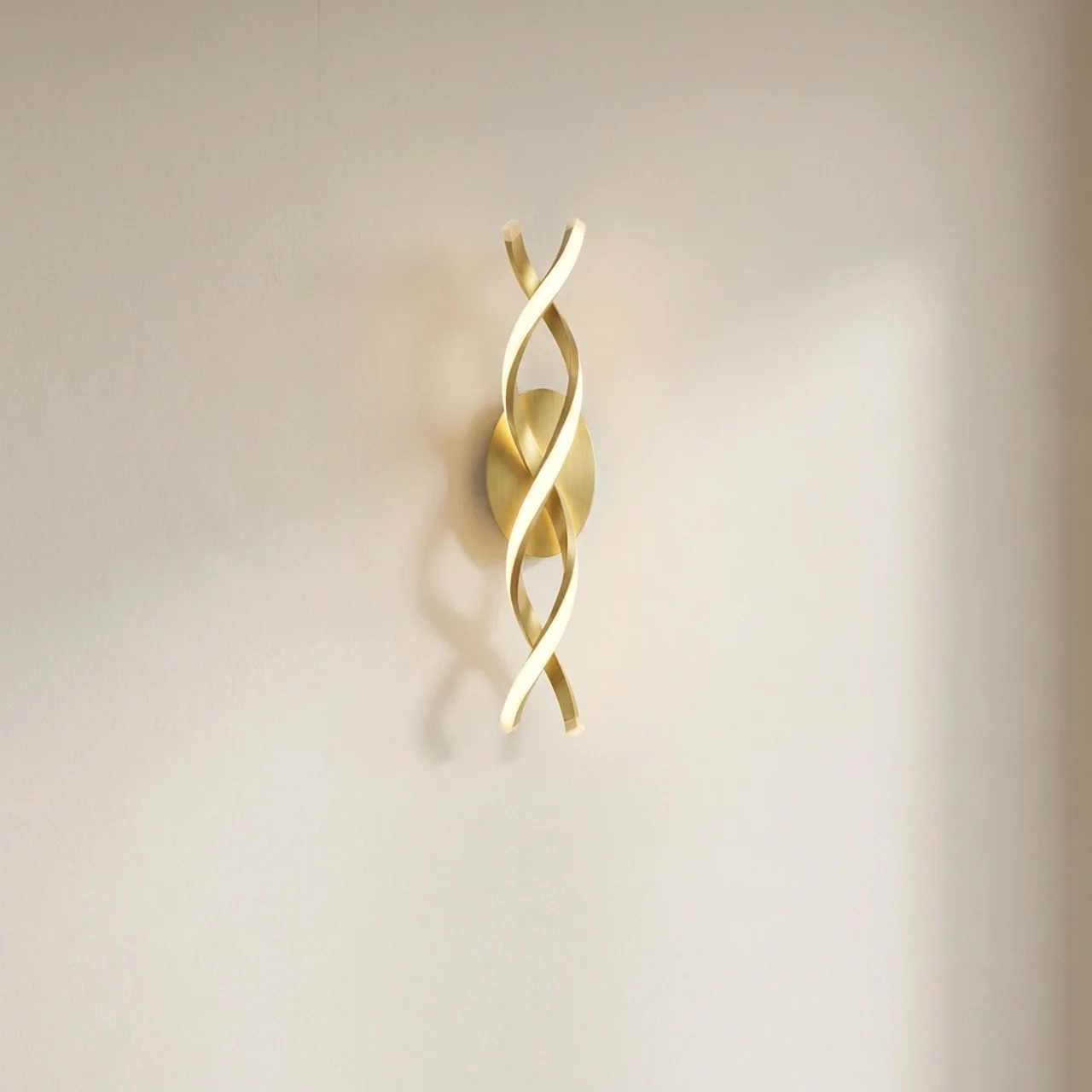 Gold wall sconce with wavy design on a neutral background