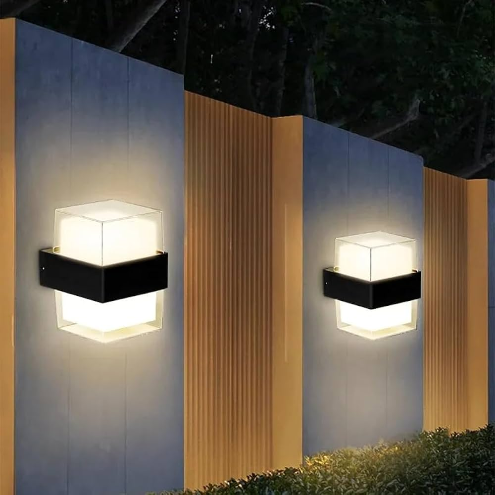 Two outdoor wall lights on a building facade at night.