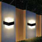 Two outdoor wall lights on a building facade at night.