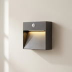 Square outdoor wall light with motion sensor on a beige wall