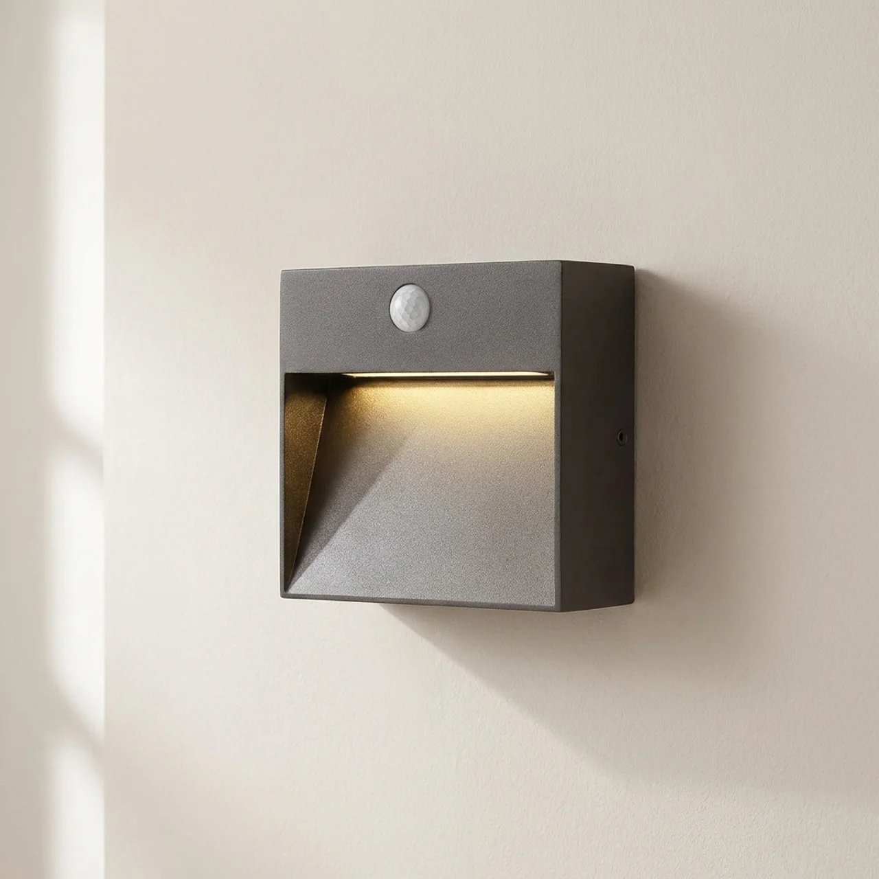 Square outdoor wall light with motion sensor on a beige wall