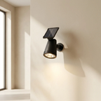 Black solar wall light fixture on a beige wall next to a window.