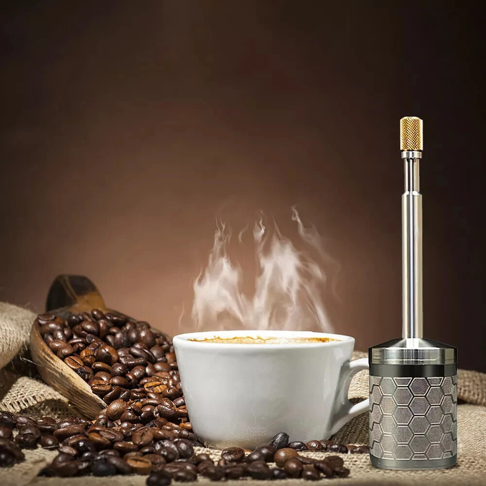 Coffee cup with steam, coffee beans, and a metallic coffee frother on a brown background