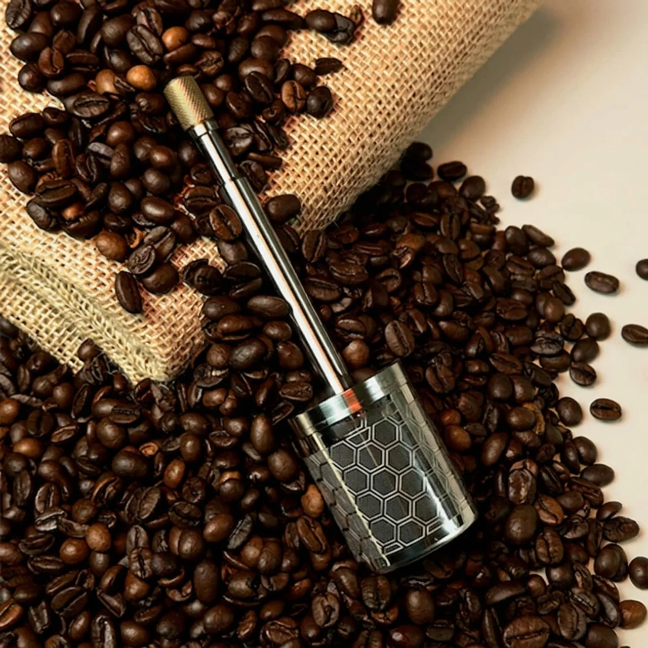 Coffee bean scoop on a bed of coffee beans with a burlap bag in the background