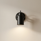 Black wall-mounted light fixture on a beige wall
