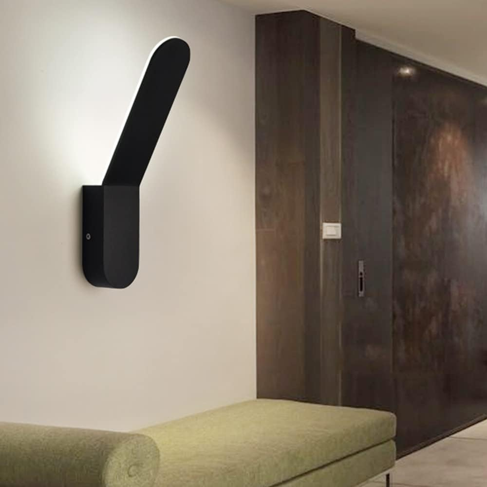 Modern black wall-mounted light fixture on a neutral wall with a bench in the foreground.