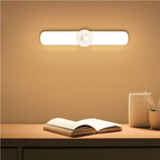 Wall-mounted light fixture on a wall with a table and book in the foreground