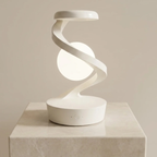 Modern white spiral table lamp on a beige pedestal against a beige background