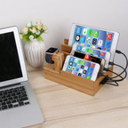 Multi-device charging station on a desk with laptop, tablet, and smartphones.