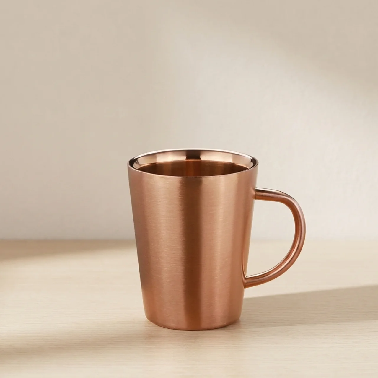 Copper mug on a beige surface with a neutral background