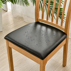 Wooden chair with a black cushion showing water droplets on a light wooden floor.